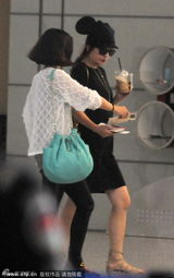 组图：赵薇戴耳朵帽现身机场 与助理卖萌玩自拍