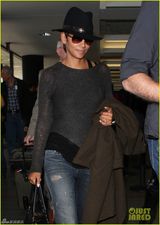 组图：哈莉贝瑞手遮孕肚面带微笑现身机场