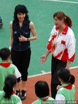 组图：张曼玉笑眯眯进校园做公益 与小粉丝亲切握手