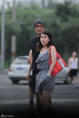 组图：梁家辉留大胡须现身北京 与一女子同返公寓