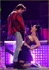 组图：凯蒂佩里跪地挺胸贴猛男 梳哪吒头表情怪