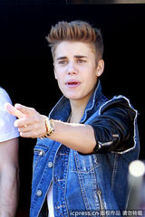 组图：比伯当街献唱谢歌迷 小天王自恋摸发