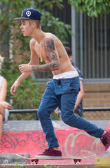 组图：比伯半裸玩滑板秀纹身 裤子滑落露小内