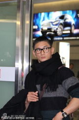 组图：吴奇隆机场歪梳小辫喜感十足