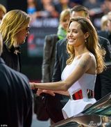 组图：朱莉白裙挽老公娇羞 皮特咬墨镜红毯卖萌