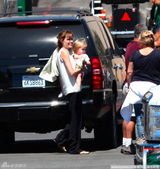 组图：茱莉不顾形象牙叼毛巾 抱女儿累坏肩膀