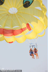 组图：蕾哈娜与好友玩跳伞 白色比基尼大秀身材