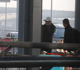 组图：刘烨现身机场难忍烟瘾 带两手机似业务忙