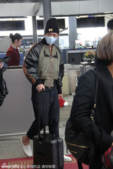 组图：柯震东戴口罩现身机场 抱大玩偶自拎行李