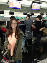 组图：王菲素颜现身机场 路人合影淡定当背景板