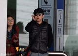 组图：黄渤携美女助理回京 机场被路人索要签名