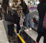 组图：杨幂口罩遮面打扮萌态 坐行李车小心护胎