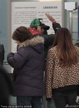 组图：谢霆锋戴绿帽机场回眸向粉丝挥挥手