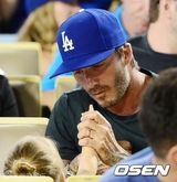 组图：小贝化身奶爸哄女儿 小七捏脸抢帽玩老爸