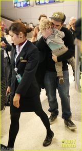 组图：歌迪亚亮相机场干练端庄 爱子卖萌