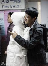 幻灯图：郭晓冬搀扶妻子出院 儿子包裹严实睡意正酣