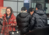 组图：黄渤携美女助理回京 机场被路人索要签名