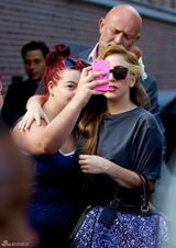 组图：Gaga头戴白花新染棕发亲和亮相