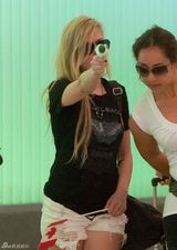 组图：艾薇儿口含棒棒糖手挥国旗开心回洛城