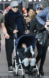 组图：林志颖护子快速离开机场 Kimi童车大睡
