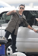 组图：吴奇隆扎时髦小辫子现身机场 与粉丝亲切聊天