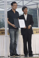 组图：陆川冒雨签约 尤小刚童心未泯无聊咬手