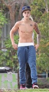 组图：比伯半裸玩滑板秀纹身 裤子滑落露小内