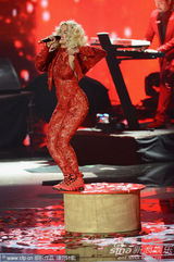 组图：Rita Ora撑黑伞演出 红色蕾丝连身裤秀身段