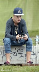 组图：比伯半裸玩滑板秀纹身 裤子滑落露小内