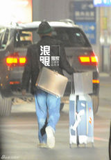 组图：徐峥戴绿边帽独自回京 把玩手机目光呆滞