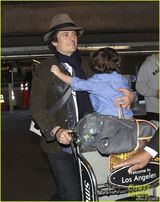 组图：奥兰多带子现身机场 小弗林害羞躲爸怀里