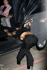 组图：Gaga戴超大孔雀头饰艰难上车俯身露乳