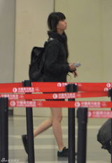 组图：小彩旗机场大方素颜示人 裸腿穿超短裙