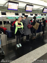 组图：王菲素颜现身机场 路人合影淡定当背景板