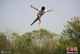 组图：钢管舞国家队秀高难度技巧 户外“悬浮”