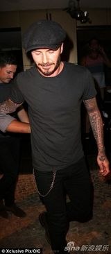 组图：小贝现身机场亲自推行李 皮衣帅气引围观