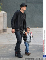 组图：奥兰多布鲁姆抱子出街 小宝贝专心舔棒冰