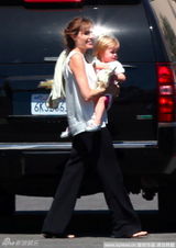 组图：茱莉不顾形象牙叼毛巾 抱女儿累坏肩膀