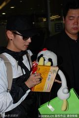 组图：李准基现身机场遭围堵 熊猫公仔遮面调皮卖萌