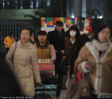 组图：张亮机场被粉丝包围 妻子见状忙回避