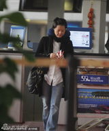 组图：袁莉携洋老公现身机场 素颜扎辫身材发福