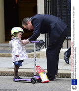 组图：英首相卡梅伦送女上学 萌娃骑爸爸肩头