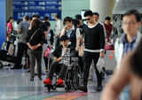 组图：黄晓明与陈可辛同机回京 坐轮椅空乘护送
