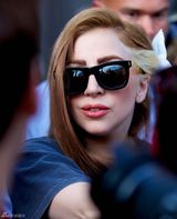 组图：Gaga头戴白花新染棕发亲和亮相