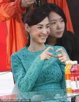 组图：张柏芝亮相变握手会 绿裙优雅难掩膝盖伤痕