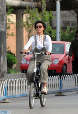 组图：张歆艺798独自骑车游玩 摘花折枝心情好