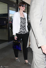 组图：安妮-海瑟薇携夫现身机场黑白搭配显干练