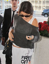 组图：赛琳娜休闲装扮亮相机场羞躲镜头