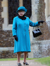 组图：英女王出席王室圣诞活动 蓝色套裙捧鲜花和蔼