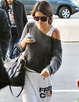 组图：赛琳娜休闲装扮亮相机场羞躲镜头